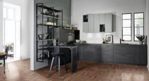 Eine moderne gestückelte L‑Form‑Küche in Anthrazit mit Patina mit integrierter Theke, offenen Regalelementen, Hängeschrank in Grau von ALPHAOMEGA.