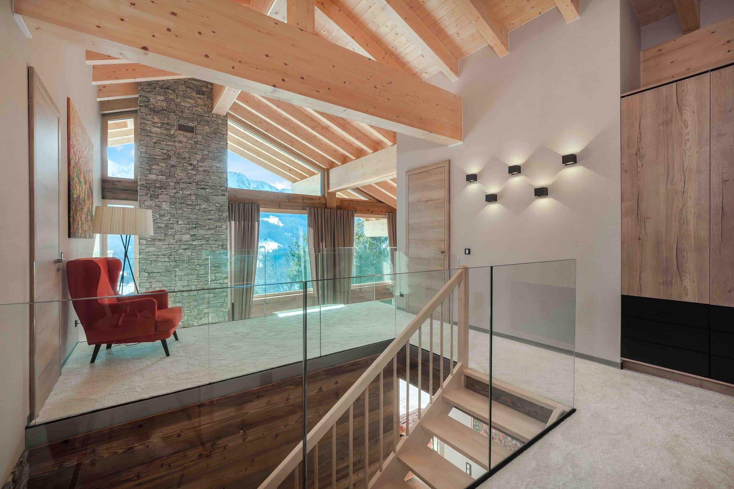 Obergeschoß eines Chalets mit Sichtdachstuhl und beidseitiger Galerie mit Nurglasgeländer von ERLER Haus.
