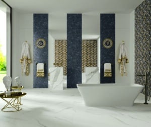 Fliesendorf zeigt ein grosses Badezimmer mit freistehender Wanne, 2 schwarz-weiss-marmorierten Waschsäulen, passenden Bodenfliesen und eine Mischung aus Wandfliesen mit Ornamenten in Dunkelblau, Silber und Gold.