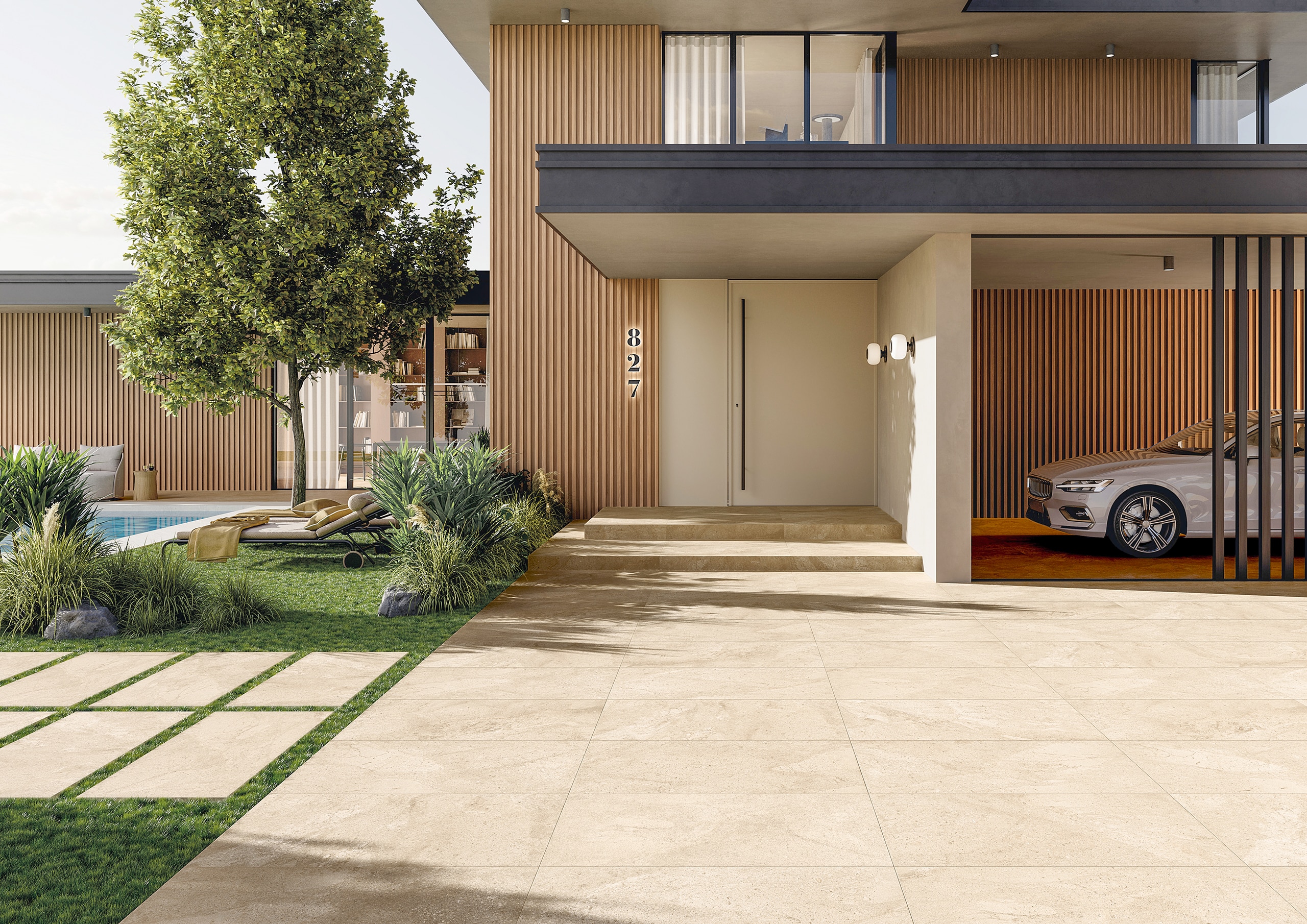 Eine moderne Villa mit fließendem Übergang zwischen Eingangs‑ und Terrassenbereich mit beigen großformatigen Steinoptik‑Außenfliesen welche ebenfalls als Trittsteine am Rasen verwendet werden von Fliesendorf.