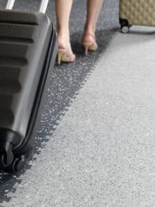 Gerflor präsentiert einen Bodenbelag in Grautönen in einem öffentlichen Gebäude, auf dem eine Dame in Stöckelschuhen geht.