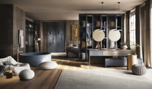 GESSI präsentiert einen großen Wellnessraum mit Duschen, freistehendem Wasserbecken mit freistehener Armatur in gold und Doppelwaschbecken mit goldener Armatur.