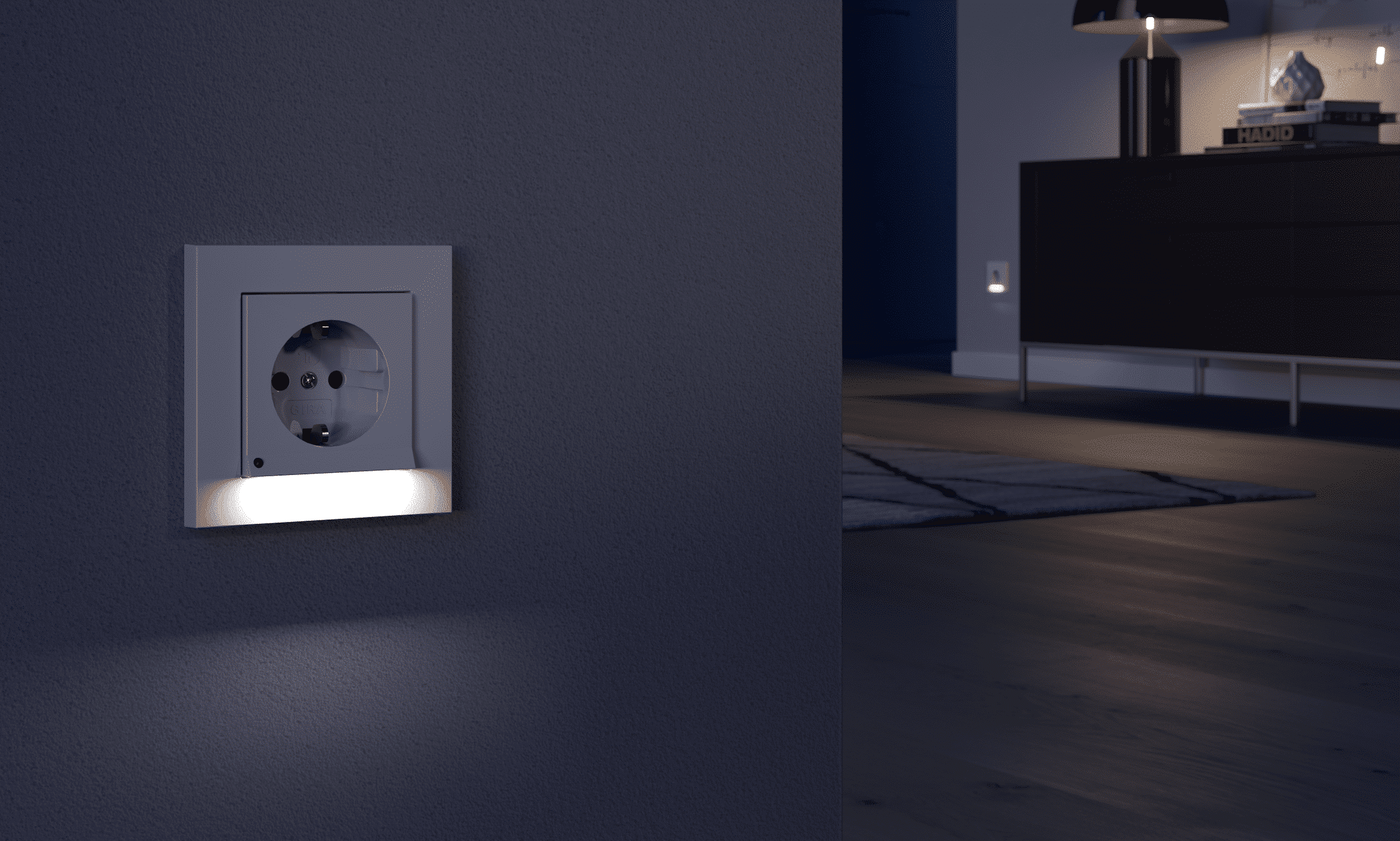 Gira zeigt eine weisse, beleuchtete Steckdose von Schuko an einer Wand zu einem dunklen Wohnzimmer mit Teppich, Kommode und einer Tischlampe.