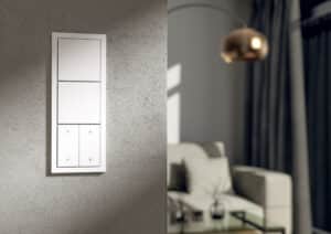 Ein Gira F200 3F Schalter in Weiß mit zwei Tastern und Jalousiensteuerung im Wohnzimmer.