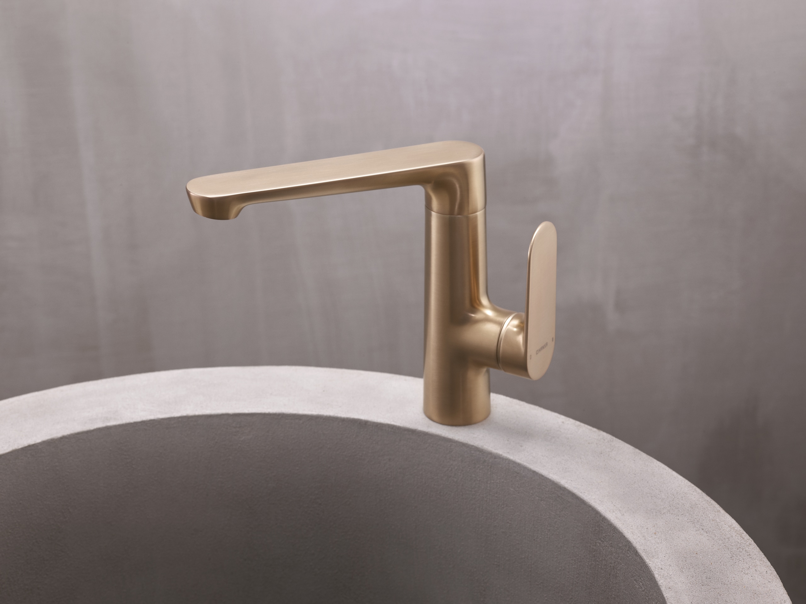 Hansa präsentiert eine elegante Armatur in gold mit seitlichem Hebel, am Beckenrand montiert.
