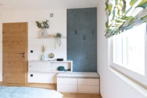 Ein Gäste bzw. Schlafzimmer mit gepolsterter Garderobe von HARTL HAUS.