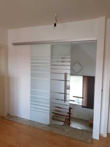 Renoviertes Obergeschoß eines Hauses mit einer Glasschiebetür aus satiniertem Musterglas als energiesparende Barriere zum alten Treppenhaus von Glaserei Hohl.