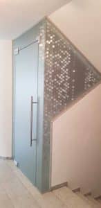 Verspielter Wohnungseingang aus Glas in einem Mehrparteienhaus mit Satinierung von Glaserei Hohl.