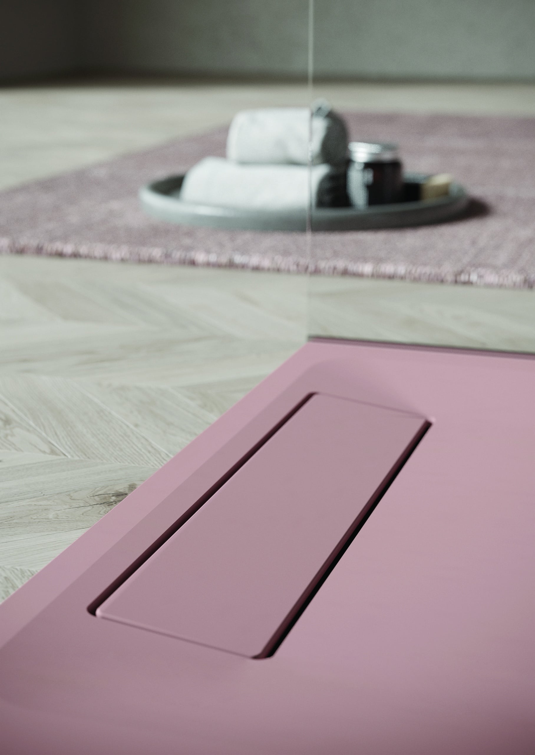 Bodengleiche Duschwanne in elegantem Rosa mit verdecktem Ablaufsystem und Glasabtrennung von Disenia.