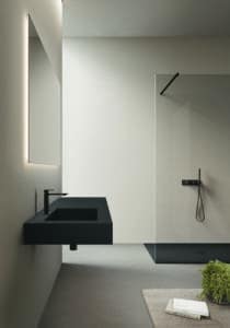 Minimalistisches Bad mit einem schwebendem schwarzen Waschbecken, bodengleicher Dusche, Glaswand und Armaturen in Mattschwarz von Disenia.