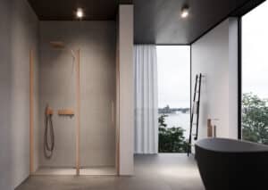 Elegante gemauerte Duschnische mit Glastür, Rahmen, Regendusche und Armatur in mattem Roségold, Wand und Bodenfliesen in grauer Steinoptik, dunkle holzvertäfelte Decke mit Spots und eine schwarze freistehende Badewanne von Disenia.