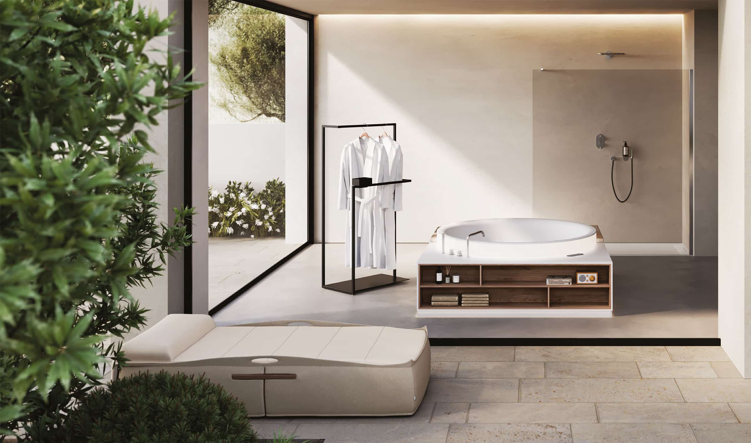 Eine in einem Badezimmer freistehende Whirlpool‑Badewanne mit Blick auf den Terrassenbereich aus der Aretusa Wellness Collection von Idea Group.