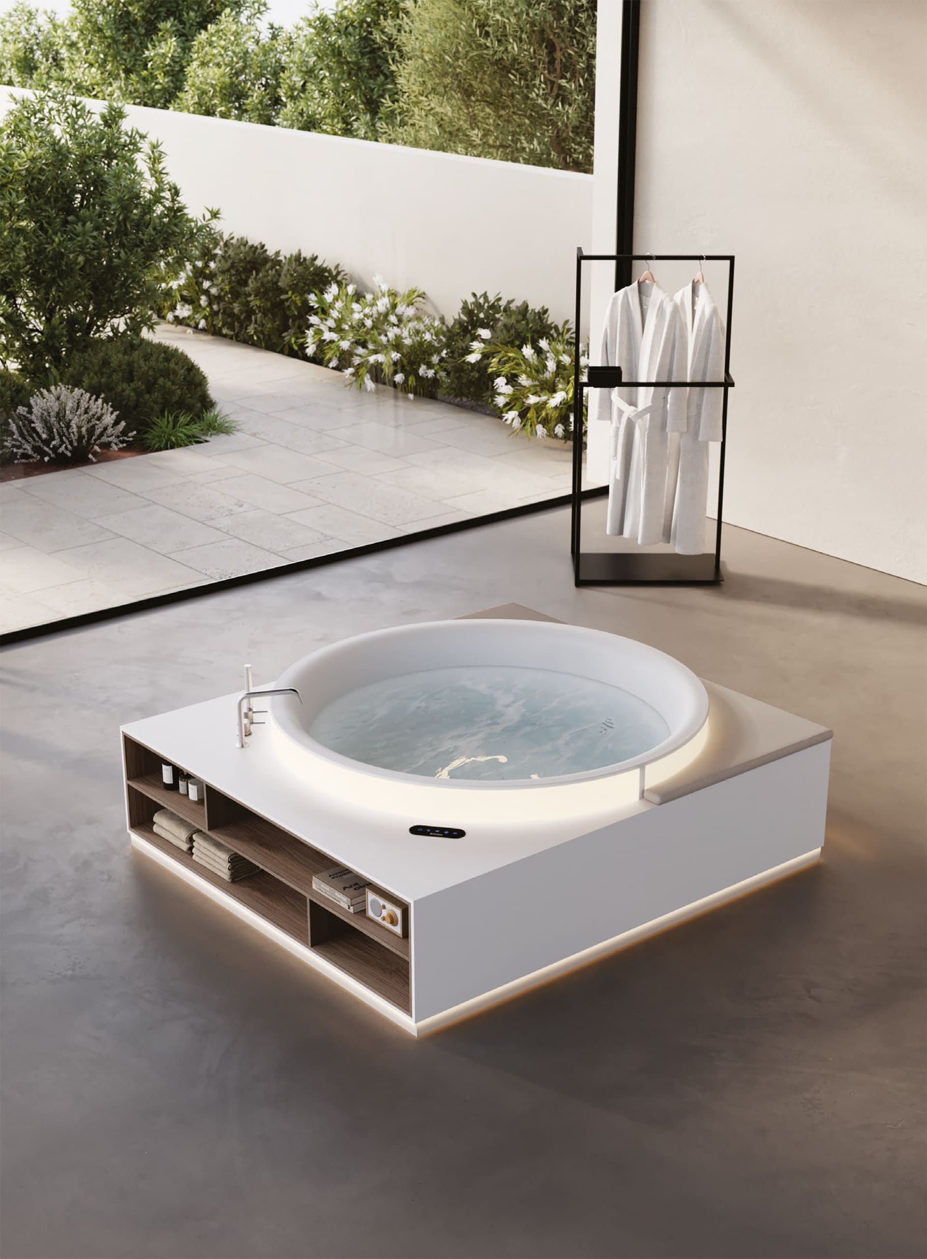 Eine in einem Badezimmer freistehende Whirlpool‑Badewanne mit Stauraum und beleuchtetem Sockel aus der Aretusa Wellness Collection von Idea Group.