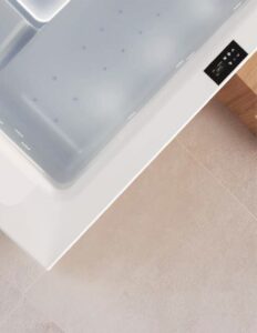 Detailaufnahme des quadratischen weißen Outdoor-Whirlpools "Gilium" mit LED-Beleuchtung, Massagedüsen und schwarzem Touchscreen-Panel von Disenia.