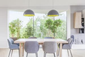 Essbereich einer Villa mit dreieckiger Fixverglasung zum freien Blick ins Grüne von Internorm.