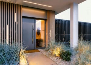Moderner Hauseingang mit anthrazitfarbener Eingangstüre mit Seitenlicht und moderner Fassadengestaltung mit Holzsprossen und Lichtstreifen von Internorm.
