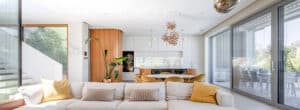 Eine moderne Villa mit offener Wohnküche, großen Glaselementen und Terrassenschiebetüren mit grauem Rahmen von Internorm.