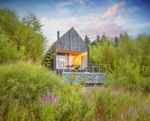 Naturverbundenes Haus mit Holz-Fassade, Terrasse, Balkon und deckenhohen Fenstern sowie einer barrierefreien Schiebetür der Serie ONE von Josko.