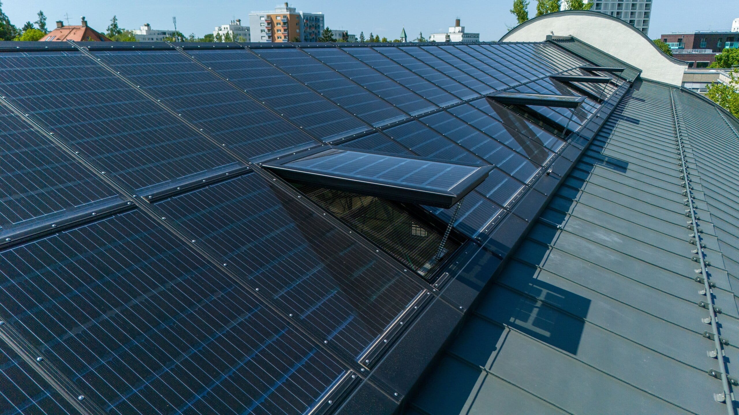 Lamilux präsentiert das Dachfenster PR60, das Fenster und Photovoltaikfläche vereint, auf einem Schrägdach.