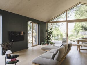 Moderne Wohnküche mit Satteldach, Holzdecke, großer Fixverglasung und Terrassenschiebetüren von M SORA.