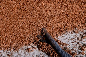 Eine Nahaufnahme des Estrich‑Füllprozesses mit Dämmmaterial von thermotec®.