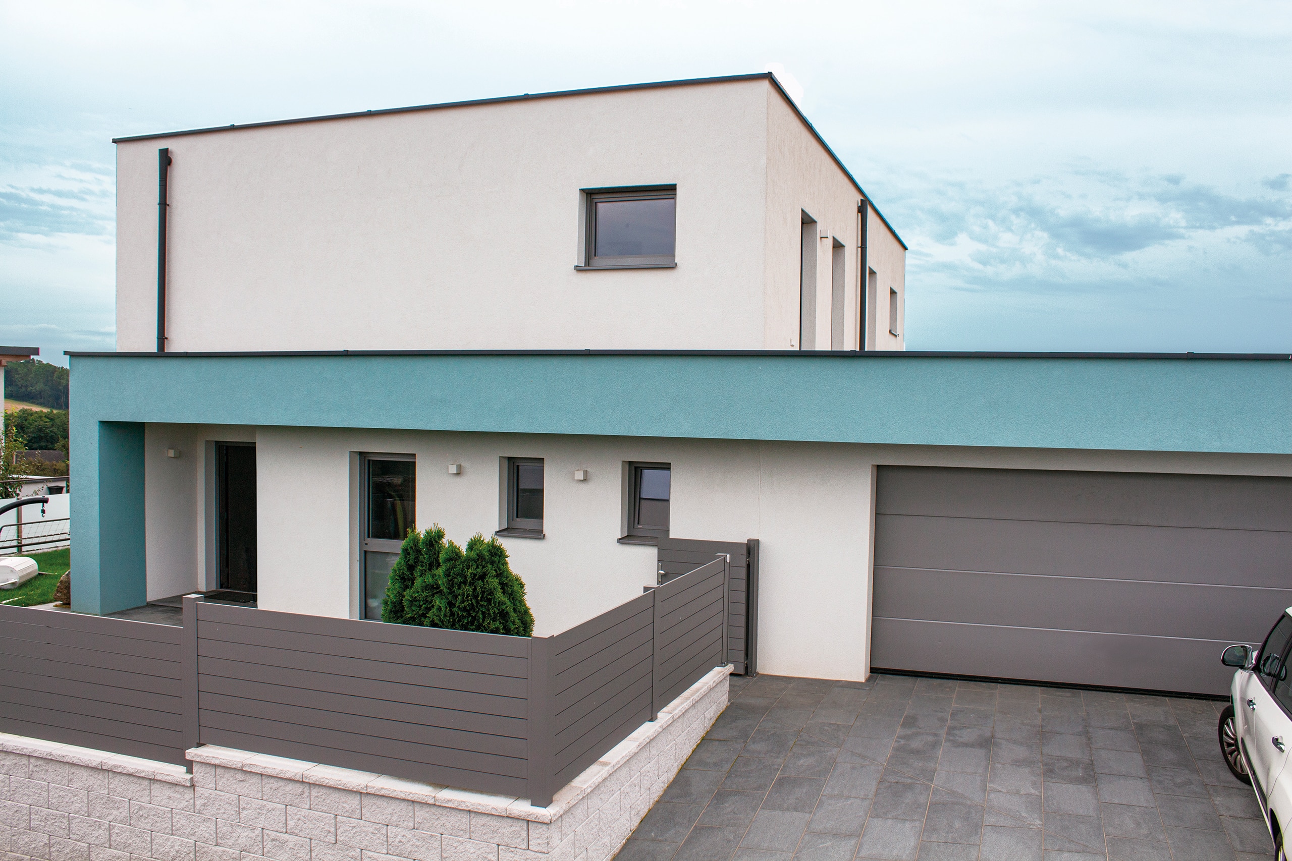Ein Einfamilienhaus mit Flachdach und Zufahrt zu einer Doppelgarage perfekt gedämmt durch thermotec®.