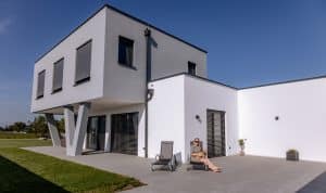 Newo Sonnen- und Insektenschutz zeigt ein Einfamilienhaus mit Terrasse und Raffstores als Beschattung.