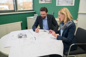 Oö. Blitzschutzgesellschaft zeigt wie ein Bauplan und die Blitzschutzplanung besprochen wird.