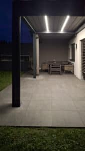 Eine schwarze Pergola mit geschlossenem Lamellendach und in die Lamellen integrierte Beleuchtung - moderne Outdoor‑Überdachung von Sonnenschutz Rachbauer.