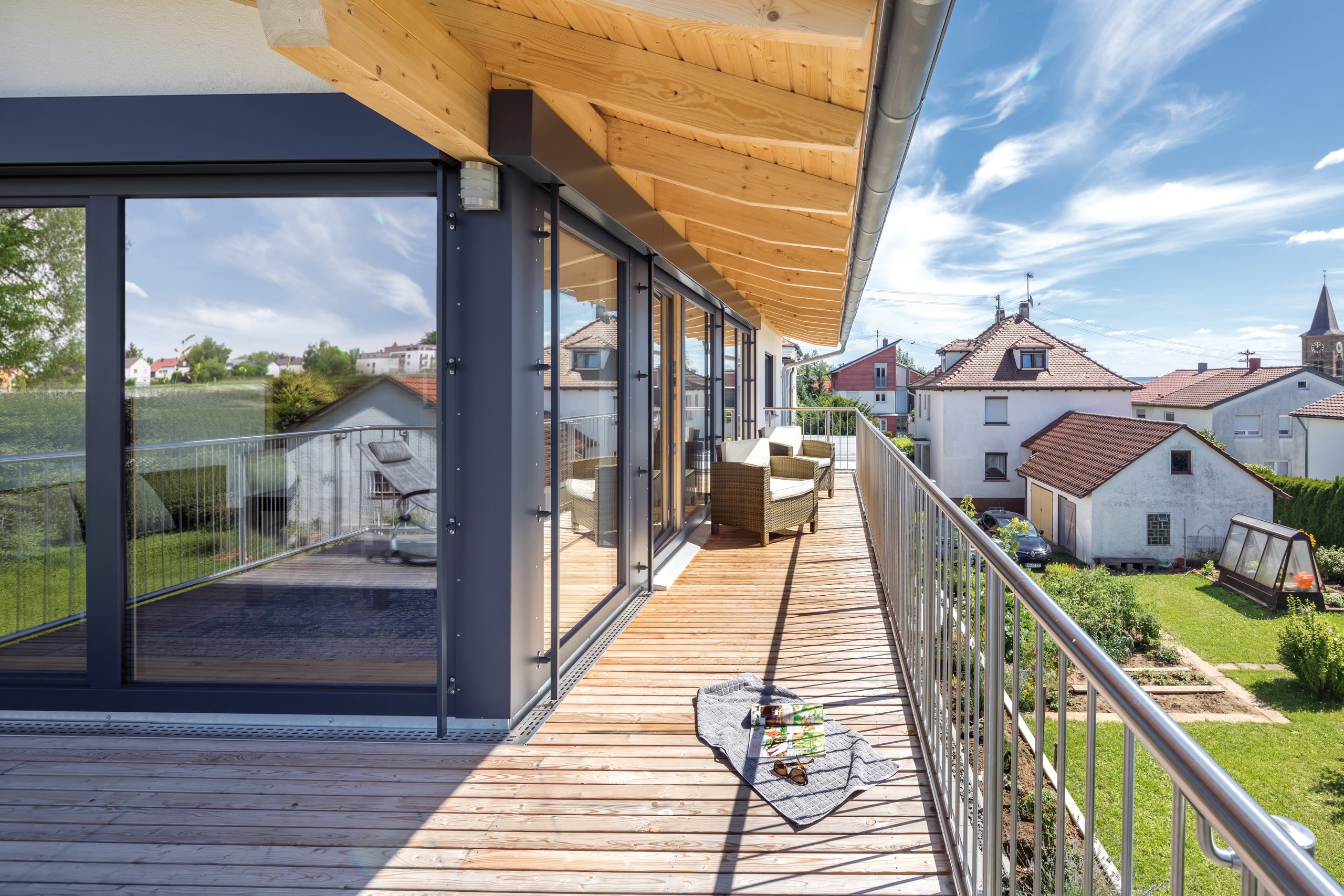 Einfamilienhaus mit großzügigem Rund-um-Balkon, Holzdielen, Eisengeländer und Dachvorsprung von Regnauer Fertighaus.