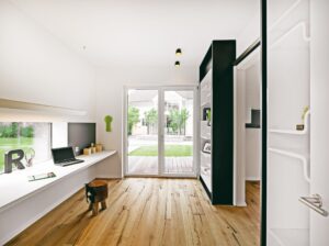 Ein modernes Arbeitszimmer mit wandlaufender Schiebetür, Deckenspots, Terrassentür, Festverglasung mit Unterlicht, einem Arbeitsplatz und schwebendem Wandboard von Regnauer.