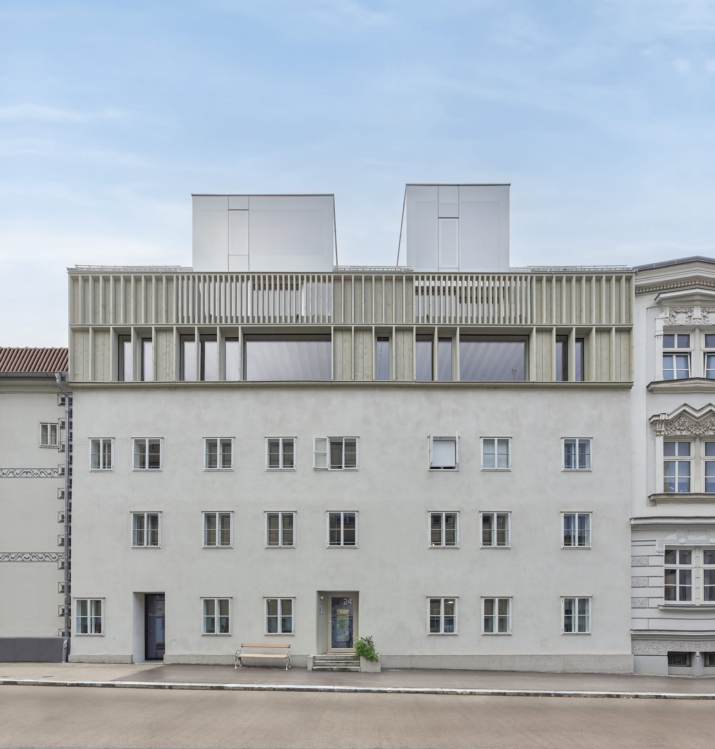 RÖFIX präsentiert die Außenansicht des Referenzprojekts Stadthaus Lederergasse mit Flachdach und grauem Außenputz.