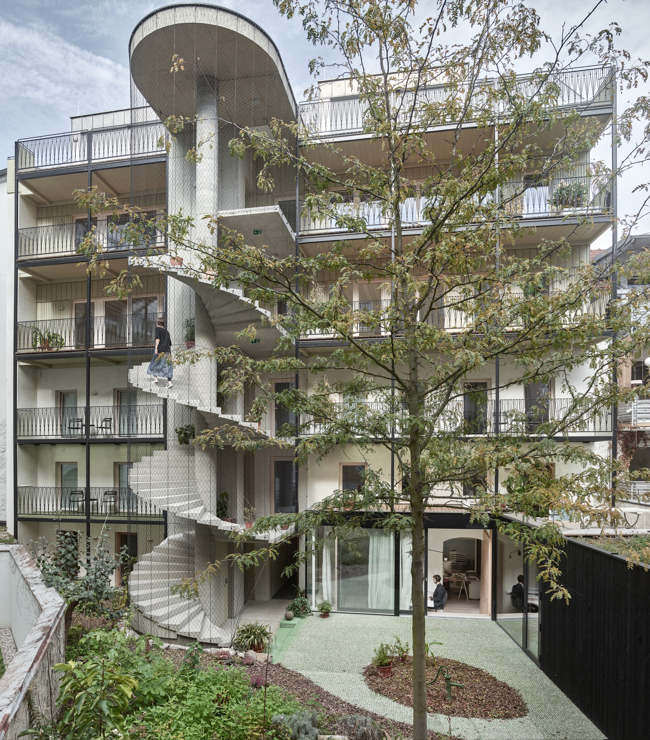 RÖFIX präsentiert das Referenzprojekt Stadthaus Lederergasse mit Flachdach, Balkonen, außenliegender großer Wendeltreppe und Innenhof.