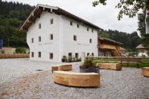 RÖFIX präsentiert die Außenansicht des Referenzprojekts Bergbauern- und Gotikmuseum mit Satteldach und beige-weißem Außenputz.