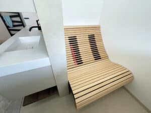 Ein entspannter Wellnessbereich mit einer hinter einer Wandnische einbgebauten Infarotliege und angrenzendem Doppelwaschtisch von Ruha Stelzmüller.