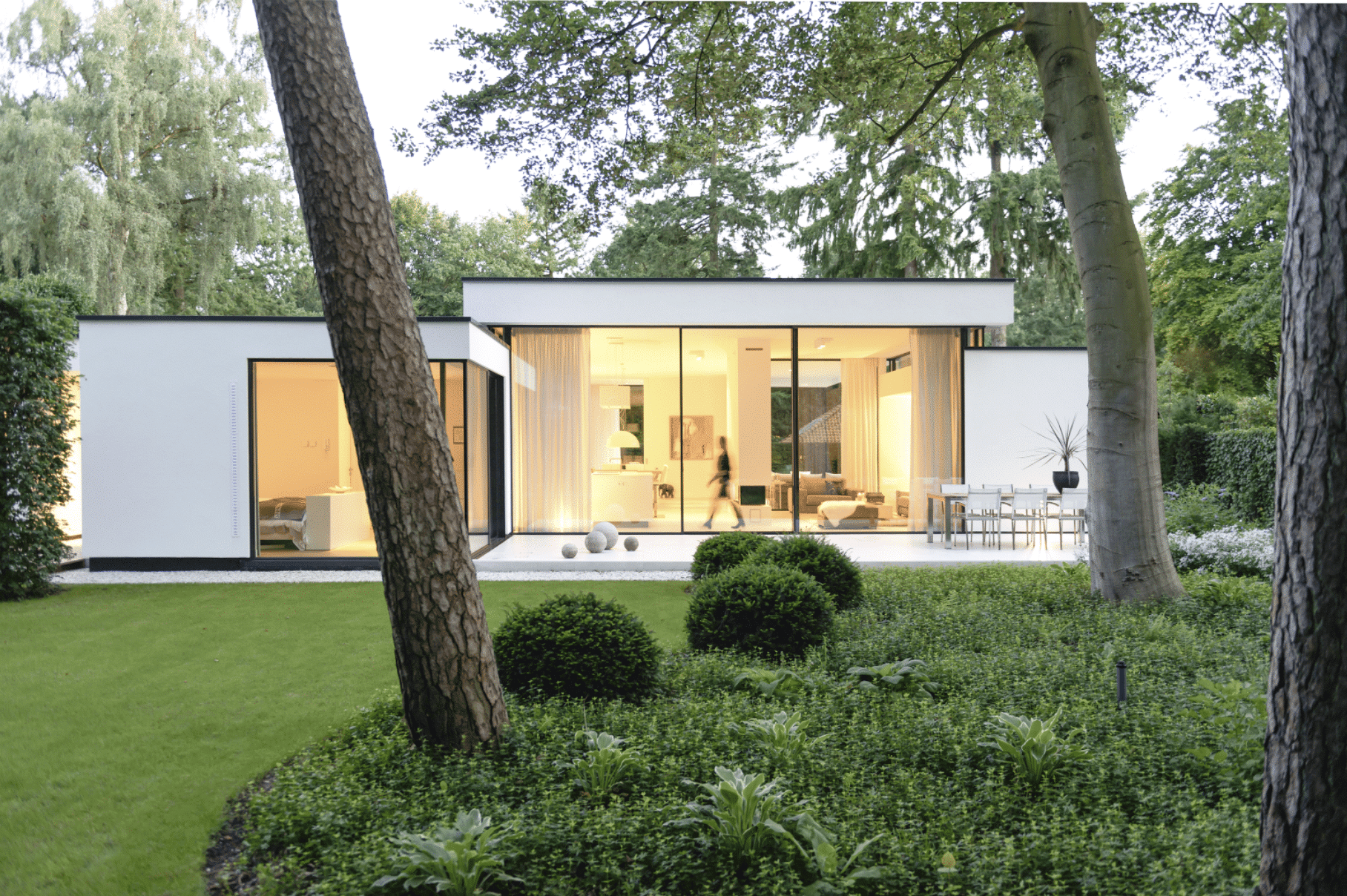 Solarlux präsentiert deren Ganzglassystem anhand eines modernen Bungalows mit Flachdach und großer Terrasse.