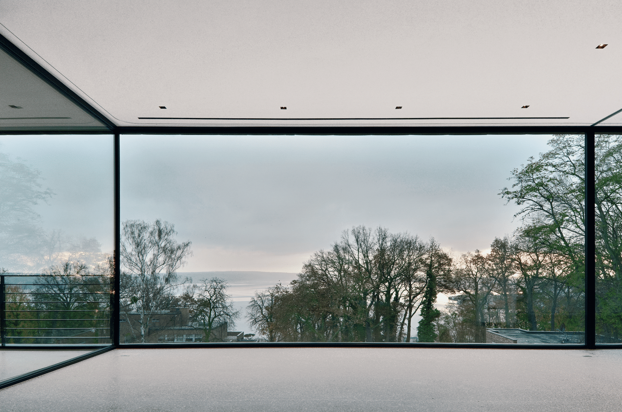 Solarlux zeigt einen hellen Raum mit Panoramafenster, Vollverglasung und schöner Aussicht inklusive Seeblick.