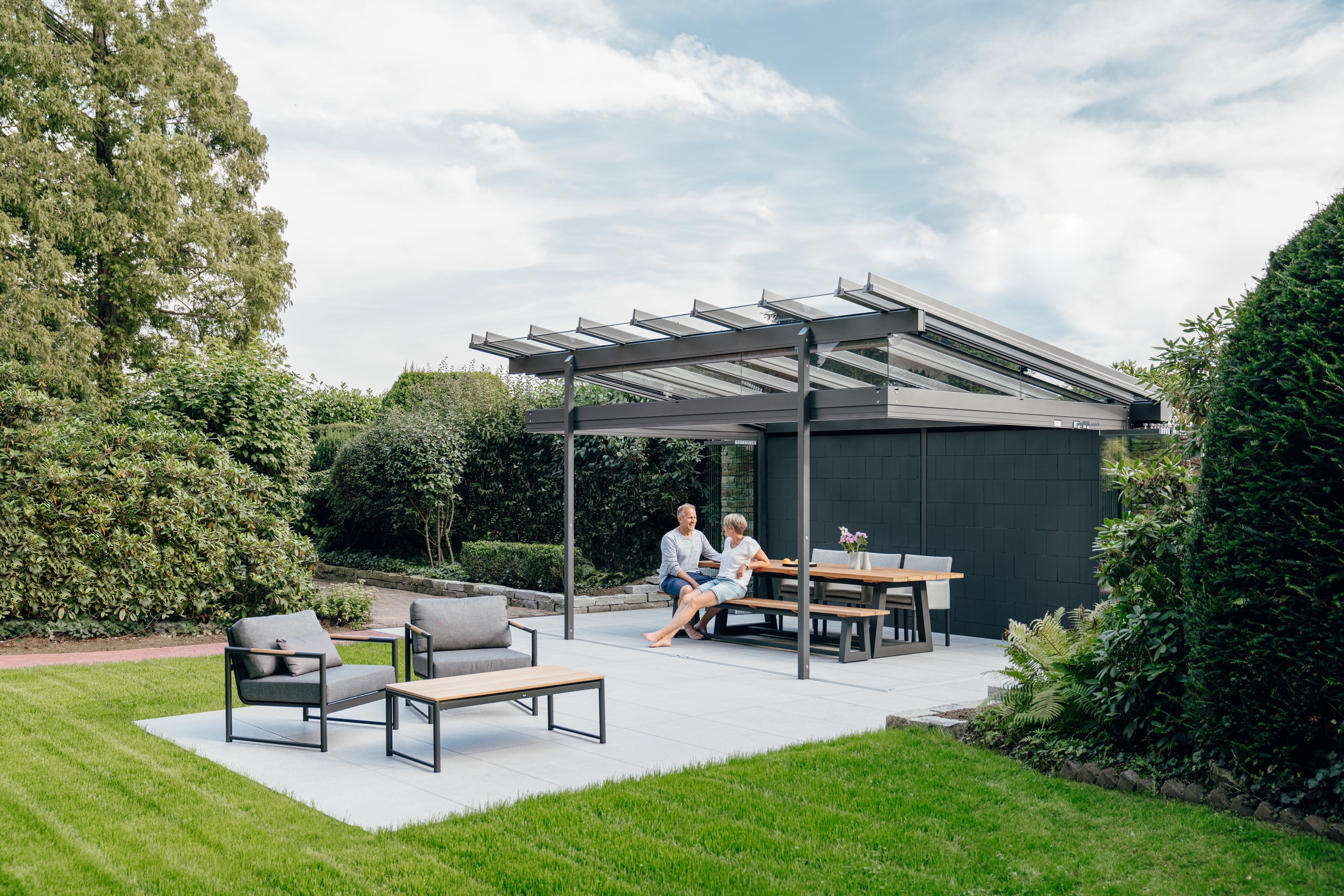 Das moderne Glashaus Atrium von Solarlux wird zur mit seinen komplett geöffneten Glasfaltwänden im Handumdrehen zur Pergola.
