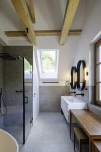 Solarlux präsentiert ein fertig saniertes Einfamilienhaus mit kleinem, aber geräumigen Badezimmer mit Dusche, Doppelwaschtisch und Schrägfenster.
