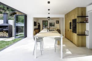Solarlux präsentiert ein fertig saniertes Einfamilienhaus mit großer offenen Küche mit Essbereich und Glasfaltwänden, die zur Terrasse hin geöffnet werden können.
