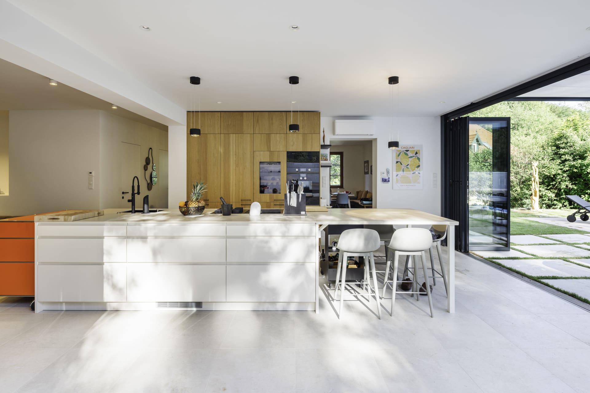 Solarlux präsentiert ein fertig saniertes Einfamilienhaus mit großer offenen Küche mit Essbereich und Glasfaltwänden, die zur Terrasse hin geöffnet werden können.