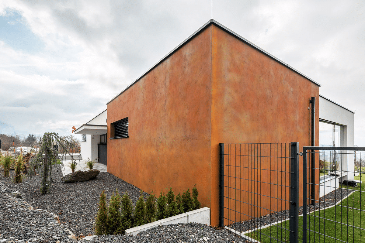 Moderner Bungalow mit einer Außenfassade in Rostoptik, gestaltet mit Synthesa Fassadenprodukten.