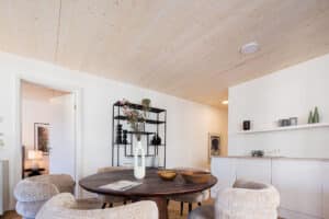 Synthesagruppe zeigt das Referenzprojekt Leopoldquartier in Wien. Eine heller Wohnung mit weißer Wandfarbe mit Parkettboden und heller Holzdecke.