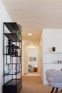 Synthesagruppe zeigt das Referenzprojekt Leopoldquartier in Wien. Eine heller Wohnung mit weißer Wandfarbe mit Parkettboden und heller Holzdecke.