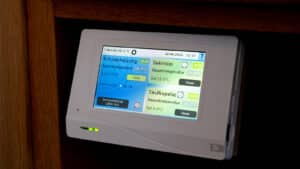 Technische Alternative RT zeigt das Display eines Heizungsreglers mit Touchscreen in einer Kirche.