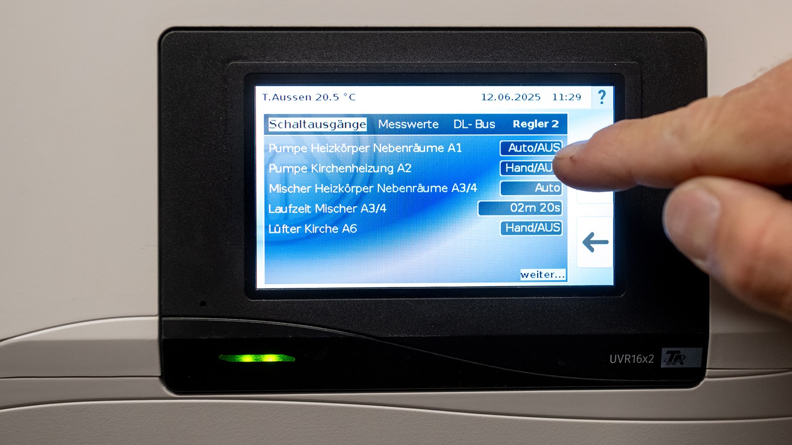 Technische Alternative RT zeigt den Heizungsregler mit Touchscreen in einer Kirche.