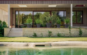 Ein Garten mit integriertem Naturpool und direktem Terrassenzugang — ein Ort der Ruhe und Erfrischung von Weissenseer.