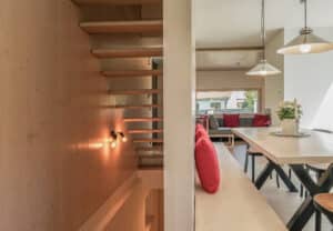 Holztreppe mit freischwebenden Stufen und schlichtem Wohnraum minimalistisch von Weissenseer.