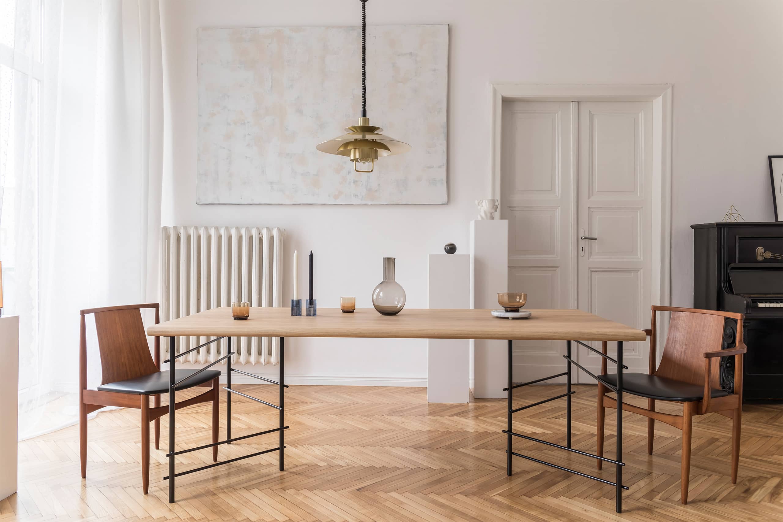 Moderner Essbereich bzw. Esszimmer in einer großzügigen Altbauwohnung mit großem Esstisch und je einen Stuhl an dessen Ende.