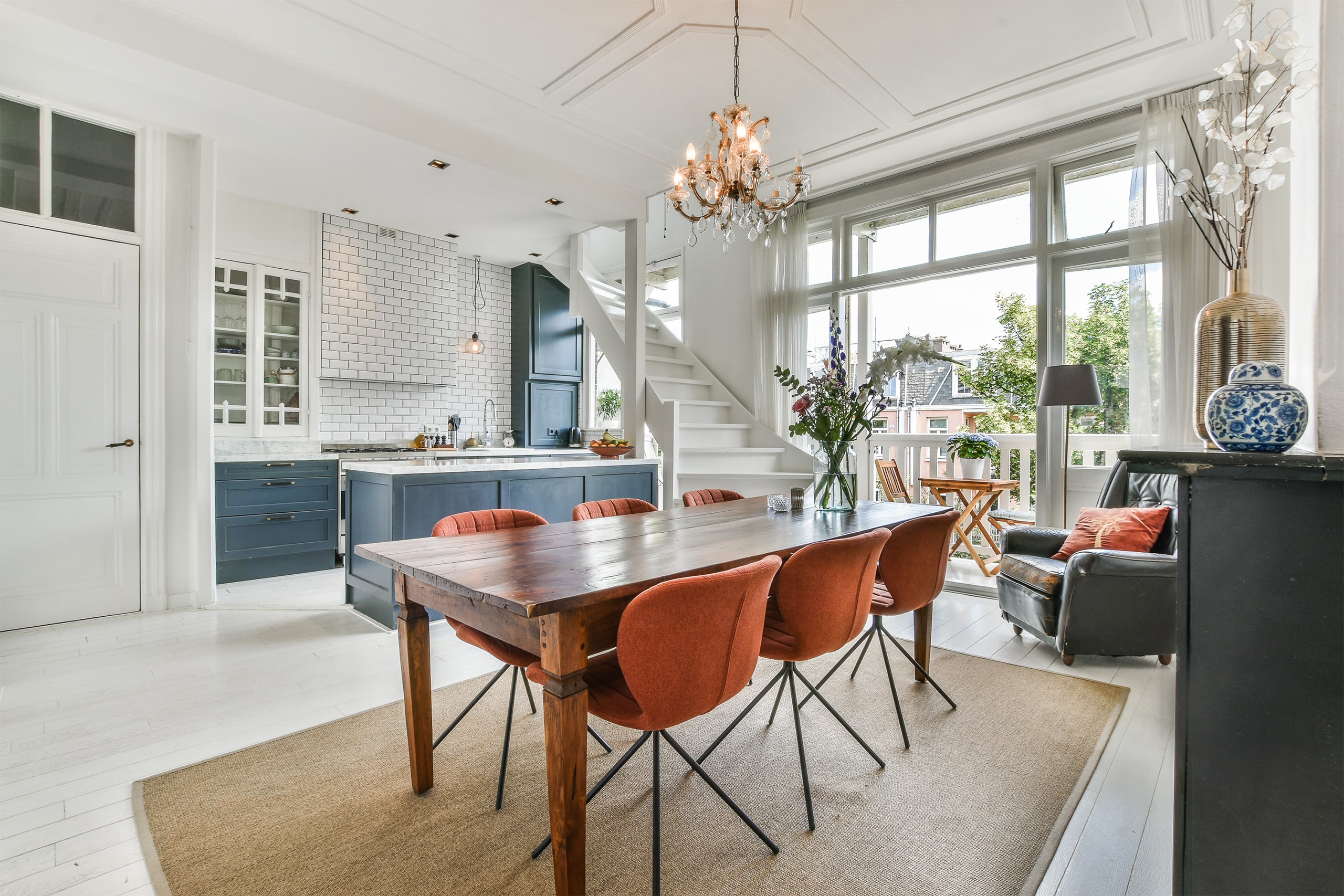 Luxuriöser und offener Wohnraum eines gemütlichen, hellen Landhauses mit Essbereich bzw. Esszimmer vor der Küche mit Kochinsel.
